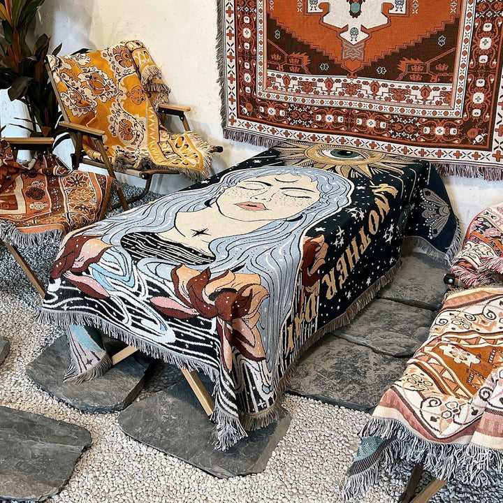 VibeCore Tomorrow Is Another Day Woven Blanket draped over a table, displaying its reversible, vibrant spiritual design. The soft cotton fabric adds a cozy, artistic touch to the room.