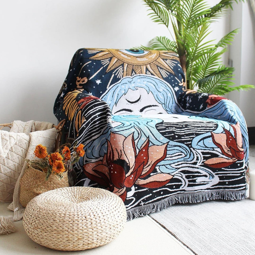 VibeCore Tomorrow Is Another Day Woven Blanket draped over a chair in a living room, featuring a spiritual design with vibrant, reversible patterns.