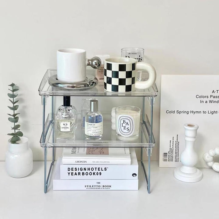 VibeCore Transparent Acrylic Foldable Shelf (2 pieces stacked) on table with belongings, showcasing minimalist design, durable acrylic, stackable, space-saving, office, storage, modern aesthetic, stylish organization, versatile, multi-purpose, clean look.