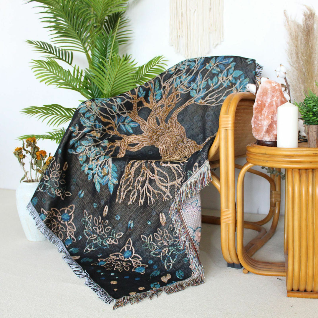 VibeCore Tree of Life Woven Blanket draped over a chair, showcasing its symbolic tree design and reversible pattern. The blanket adds warmth and style to the space with its timeless aesthetic.