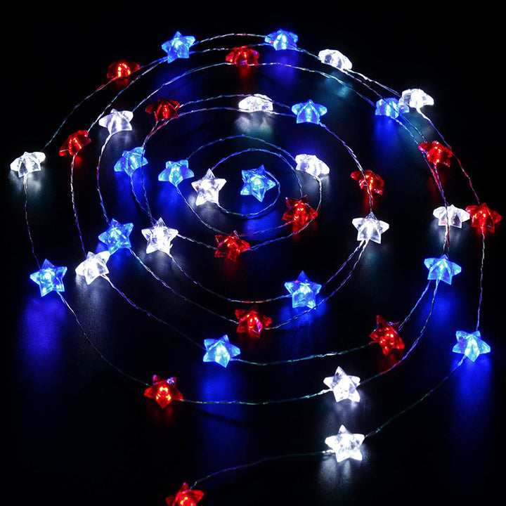 VibeCore Tricolor Stars Fairy Lights on table, viewed from above, showcasing the vibrant blue, red, and white stars. Battery-powered with 30 lights and 8 light modes for a customizable, cozy ambiance.