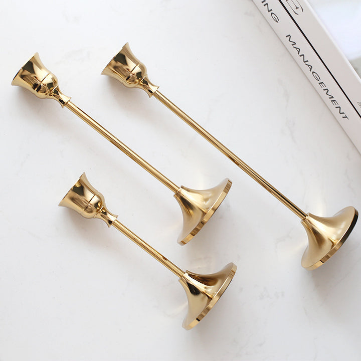 VibeCore Vintage Golden Candle Holder, all 3 sizes lying down on table, crafted from high-quality iron and brass with a sleek golden finish, offering European elegance and a timeless aesthetic for any room.