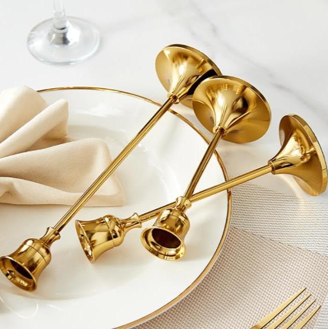 VibeCore Vintage Golden Candle Holder laid down on table, crafted from high-quality iron and brass with a sleek golden finish, adding European charm and elegance to your space while creating a warm, inviting ambiance.