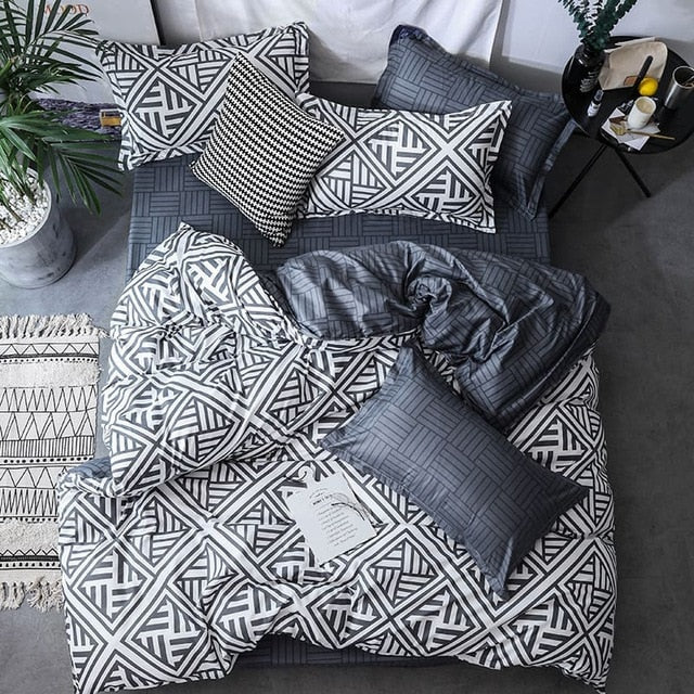 Aerial view of the VibeCore Aesthetic Aztec Geometric Duvet Cover Set in black and white, showcasing bold, symmetrical patterns inspired by Aztec design. Made from a soft cotton-polyester blend, this duvet cover set adds modern sophistication and comfort to any bedroom or dorm room.