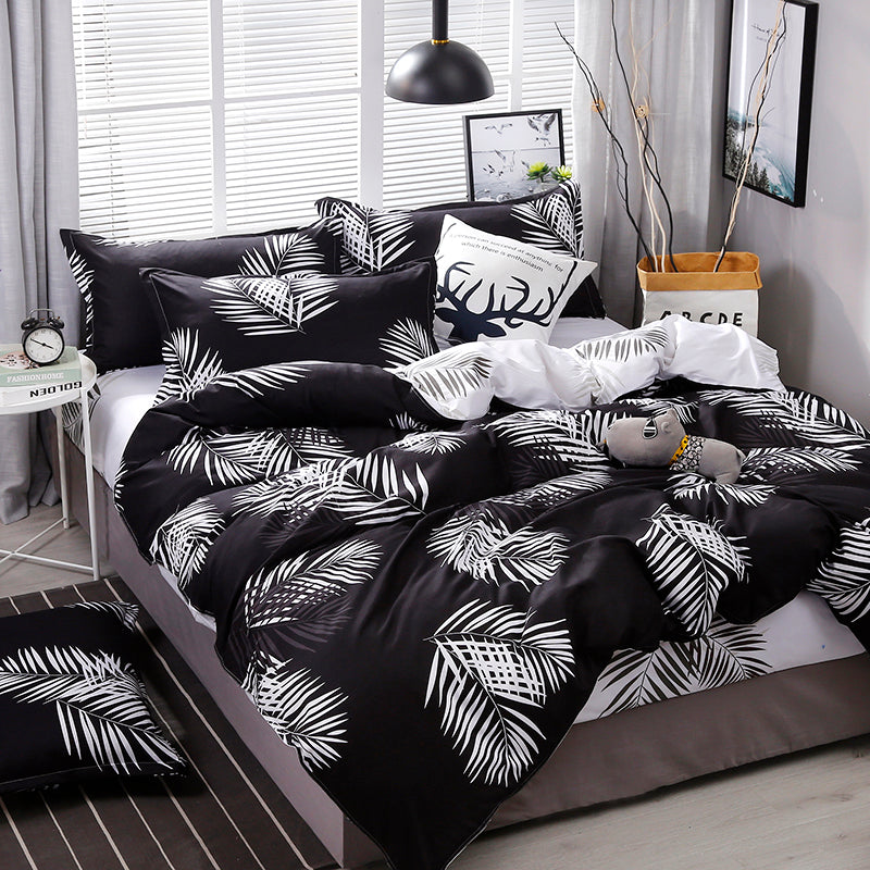 Aerial angled view of the VibeCore Aesthetic Black Leaf Duvet Cover Set, showcasing a bold black and green leaf pattern. The soft cotton-polyester blend fabric provides comfort and durability, making it an elegant addition to any modern bedroom or dorm room.