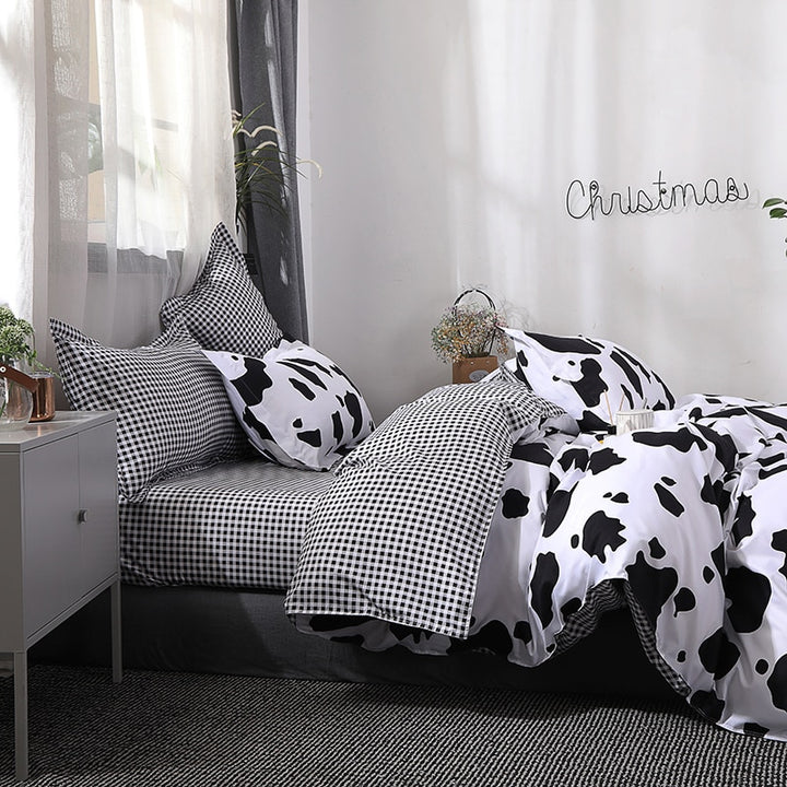 Full side view of the VibeCore Cow Print Bedding Set, highlighting the interior duvet cover with a black gingham pattern. Made from a soft cotton-polyester blend, this bedding set features a trendy mix of cow print and gingham, offering a stylish and cozy addition to your bedroom décor.