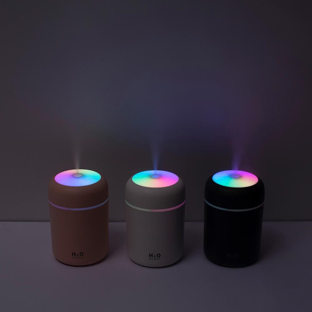 A soothing display of white, blossom, and gray diffusers releasing mist and vibrant LED lights, enhancing the atmosphere with calming colors and aromas.