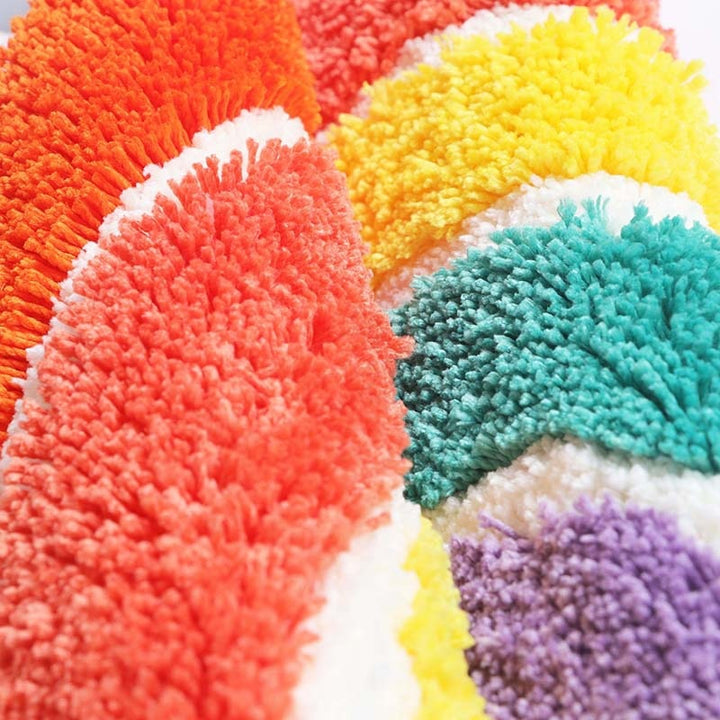 VibeCore Rainbow Plush Rug made from durable polyester fiber, offering a soft, fluffy texture. Water-absorbent and designed with a non-slip backing for added safety and comfort. Easy to clean and maintain, perfect for any space.